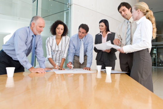 Consultants discussing strategy around a conference table